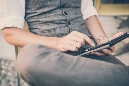 handsome big moustache hipster man using tablet sitting at the barの写真素材