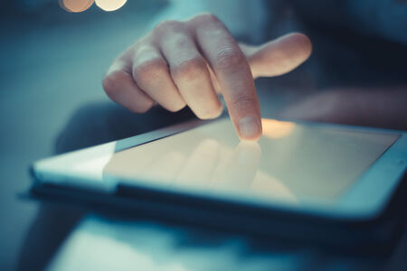 close up hand man using tablet at the bar with beer on tableの写真素材