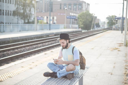 young handsome hipster gay modern man using smartphone in townの写真素材