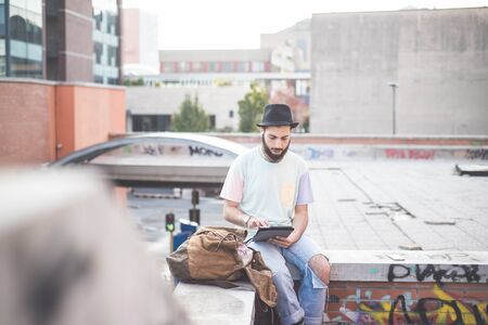 young handsome hipster gay modern man using tablet in townの写真素材