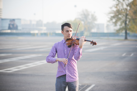 young crazy funny musician violinist asian man in town outdoor lifestyleの写真素材