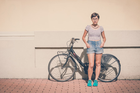 young hipster woman with bike in the cityの写真素材