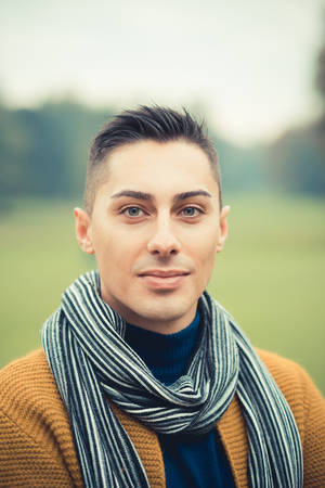 young handsome caucasian man in autumn park outdoorの写真素材