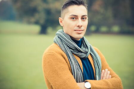 young handsome caucasian man in autumn park outdoorの写真素材
