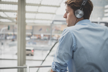 young model hansome blonde man with headphones in the cityの写真素材