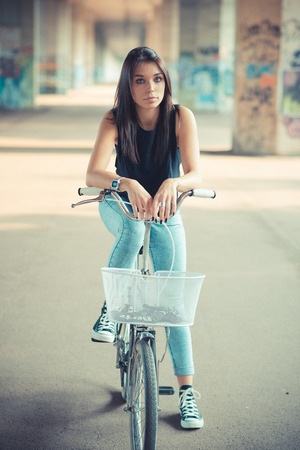 young beautiful brunette straight hair woman using bike outdoorの写真素材