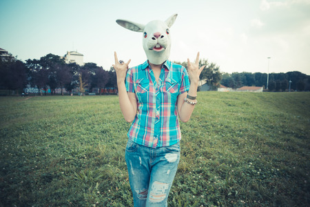 rabbit mask absurd beautiful young hipster woman in the cityの写真素材