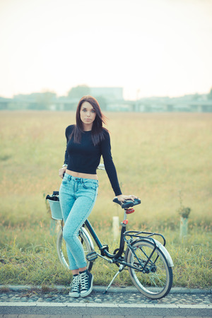 young beautiful brunette straight hair woman using bike outdoorの写真素材
