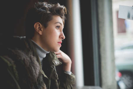 young beautiful short hair hipster woman at the bar drinking coffee