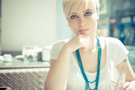 beautiful young blonde short hair hipster woman at the cafeの写真素材