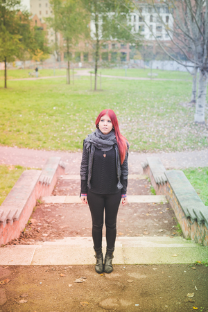 young beautiful red hair venezuelan woman lifestyle in the city of milan outdoor streetの写真素材