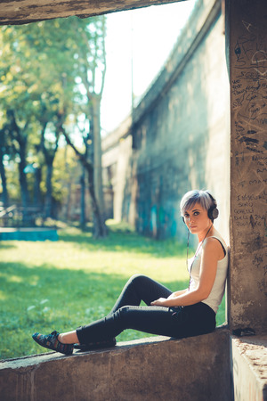 young beautiful short blue hair hipster woman with headphones music in the cityの写真素材