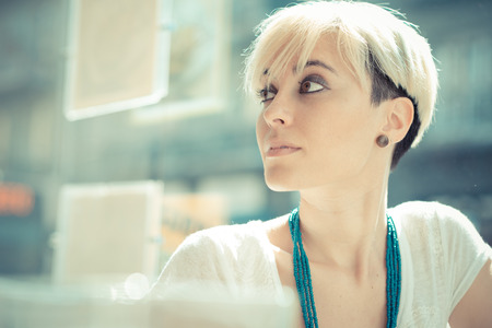 beautiful young blonde short hair hipster woman at the cafeの写真素材