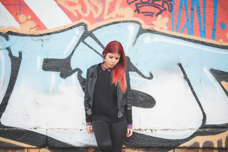 young beautiful red hair venezuelan woman lifestyle in the city of milan outdoor streetの写真素材