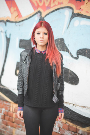 young beautiful red hair venezuelan woman lifestyle in the city of milan outdoor streetの写真素材