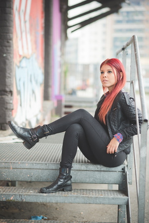 young beautiful red hair venezuelan woman lifestyle in the city of milan outdoor streetの写真素材