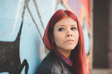young beautiful red hair venezuelan woman lifestyle in the city of milan outdoor streetの写真素材