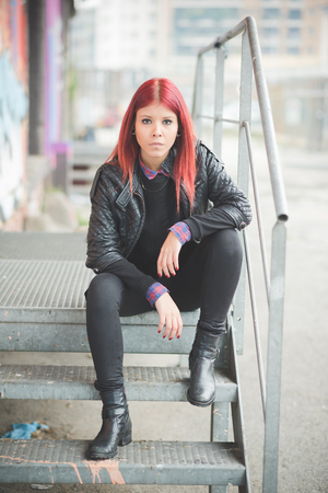 young beautiful red hair venezuelan woman lifestyle in the city of milan outdoor streetの写真素材