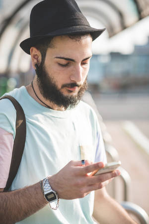 young handsome hipster modern man using smartphone in townの写真素材