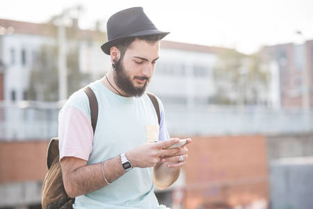 young handsome hipster modern man using smartphone in townの写真素材