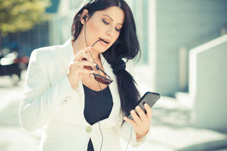 beautiful long black hair elegant business woman using smartphone  in the cityの写真素材