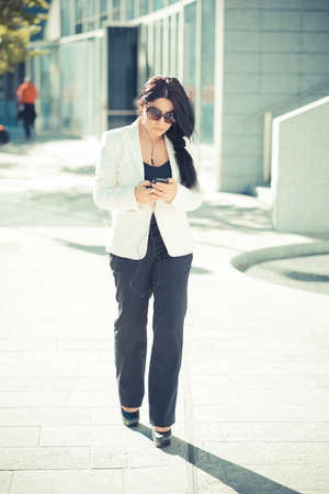 beautiful long black hair elegant business woman using smartphone  in the cityの写真素材