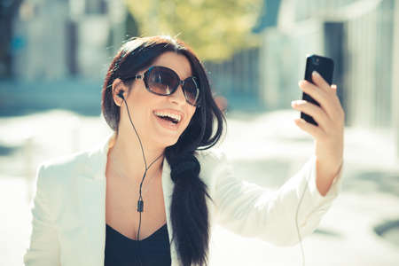 beautiful long black hair elegant business woman using smartphone  in the cityの写真素材