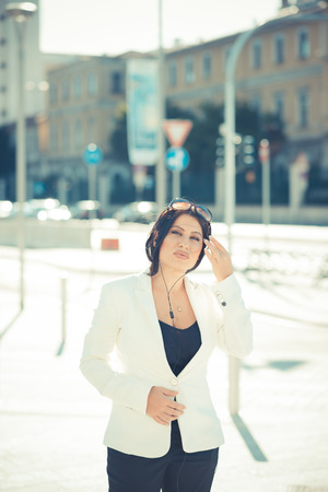 beautiful long black hair elegant business woman with earphones in the cityの写真素材