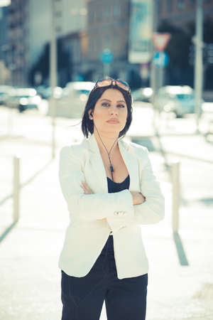 beautiful long black hair elegant business woman with earphones in the cityの写真素材