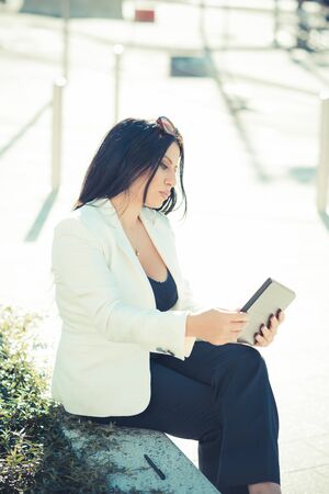beautiful long black hair elegant business woman using tablet in the cityの写真素材