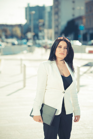 beautiful long black hair elegant business woman using tablet in the cityの写真素材
