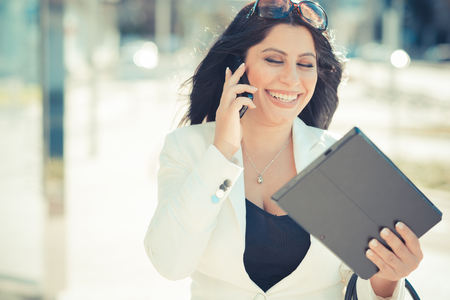 beautiful long black hair elegant business woman using tablet in the cityの写真素材