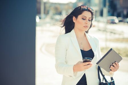 beautiful long black hair elegant business woman using tablet in the cityの写真素材