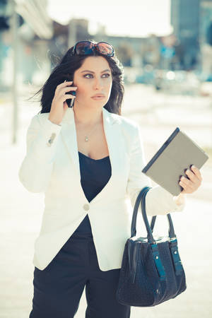 beautiful long black hair elegant business woman using tablet in the cityの写真素材