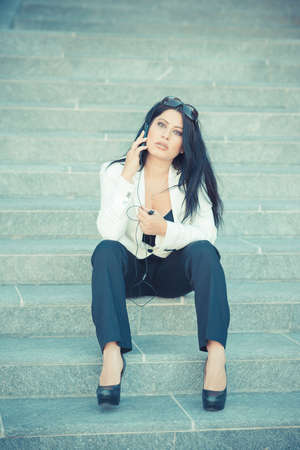 beautiful long black hair elegant business woman using smartphone in the cityの写真素材