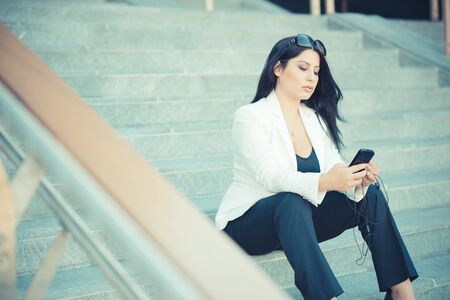 beautiful long black hair elegant business woman using smartphone in the cityの写真素材