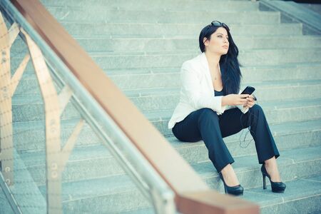 beautiful long black hair elegant business woman using smartphone in the cityの写真素材