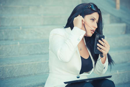 beautiful long black hair elegant business woman using smartphone in the cityの写真素材