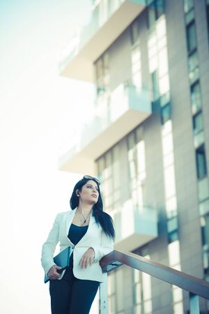 beautiful long black hair elegant business woman with tablet  in the cityの写真素材