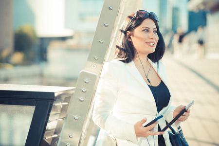 beautiful long black hair elegant business woman with tablet  in the cityの写真素材