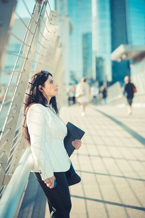beautiful long black hair elegant business woman with tablet  in the cityの写真素材