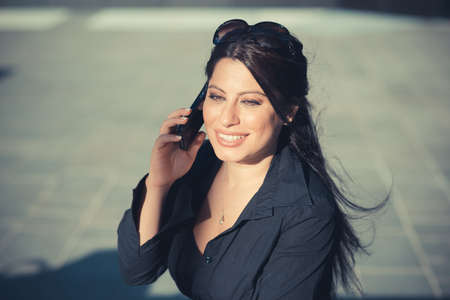 beautiful long black hair elegant business woman using smartphone in the cityの写真素材