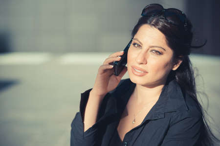 beautiful long black hair elegant business woman using smartphone in the cityの写真素材