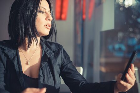 beautiful long black hair elegant business woman using tablet and smartphone in the cityの写真素材