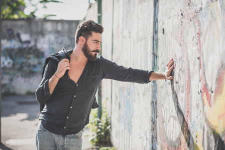 young handsome attractive bearded model man in urban contextの写真素材