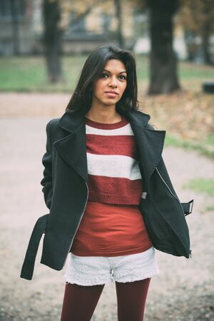 young beautiful indian woman at the park in autumnの写真素材