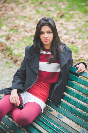 young beautiful indian woman at the park in autumnの写真素材