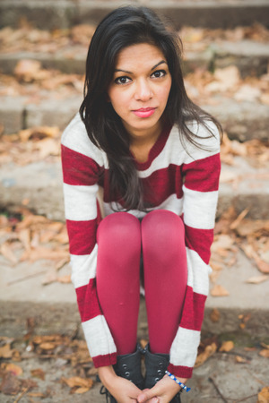 young beautiful indian woman at the park in autumnの写真素材