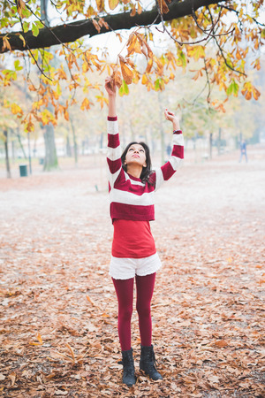 young beautiful indian woman at the park in autumnの写真素材