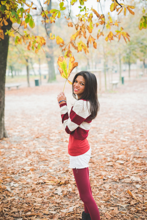 young beautiful indian woman at the park in autumnの写真素材